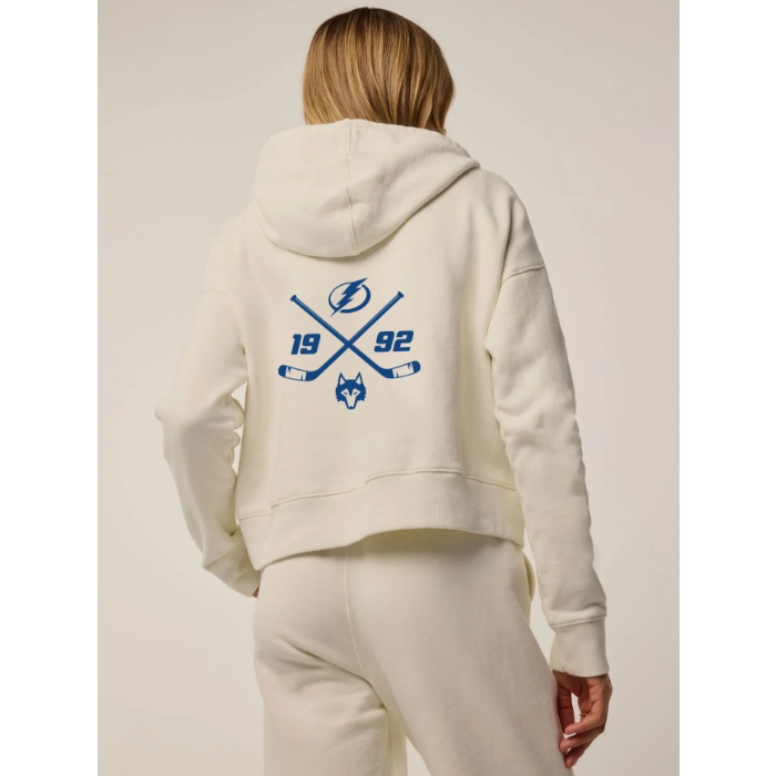 Person wearing a cream hoodie with sports-themed design on the back against a neutral background