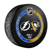 Hockey puck with NHL logo and Tampa Bay Lightning and Pittsburgh Penguins logos on a black background